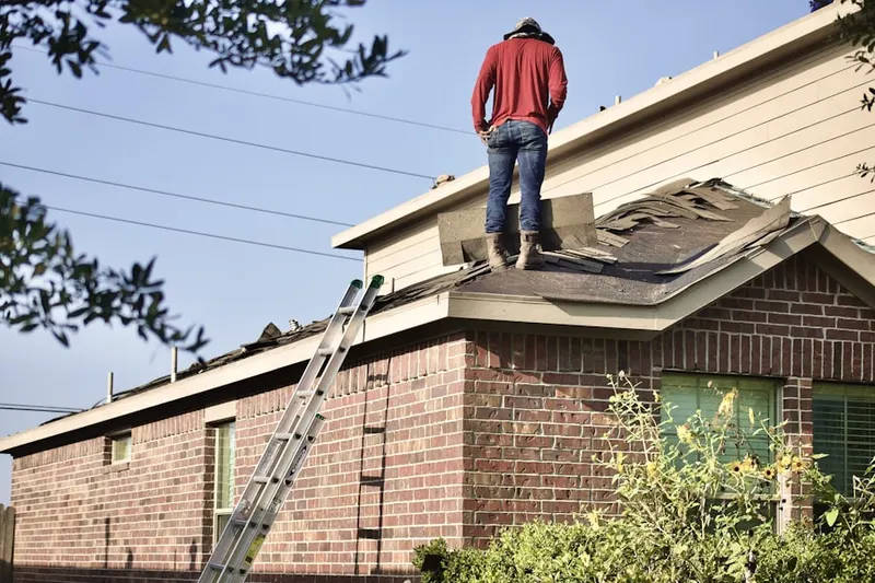 Professional roofer working on a residential roof in Maize